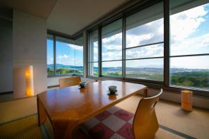 a dining room with a table and chairs and large windows at Omuta Heights in Ōmuta