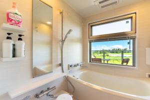 a bathroom with a tub and a sink and a window at Ocean Resort Maeda / Vacation STAY 3223 in Onna +34 photos
