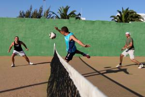 a group of men playing soccer on a tennis court at Sotavento Beach Club in Costa Calma