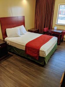 ein Hotelzimmer mit einem großen Bett und einem Schreibtisch in der Unterkunft Jets Motor Inn in Queens
