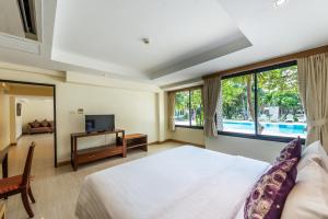 a bedroom with a large bed and a television at Hotel Tropicana Pattaya - SHA Extra Plus by D N A in Pattaya