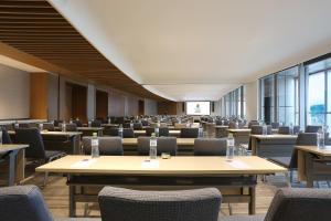 una grande stanza con tavoli, sedie e finestre di Hyatt Place Sanya City Center a Sanya Altre 135 foto