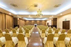 una sala de conferencias con filas de sillas y un podio en Hotel Tropicana Pattaya, en Pattaya central