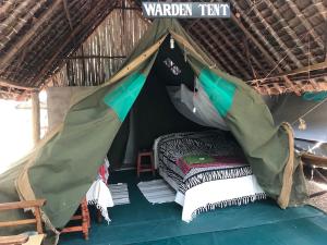 a bed in a tent in a field at Maasai Simba Camp in Amboseli