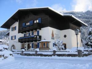 a large building with snow on the ground at Pension Appartments Christoph in Westendorf
