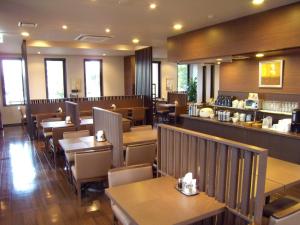 名取市名取罗特茵酒店的有木桌椅和酒吧的餐厅