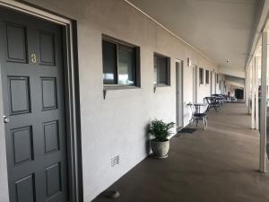 um corredor com uma porta e um vaso de plantas em Allan Cunningham Motel -Under New Management- em Toowoomba