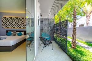 a bedroom with a bed and a table and chairs on a balcony at Sea Suite Villa in Bang Rak Beach