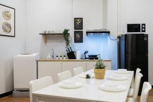 a kitchen with a white table and white chairs at U3 Large 2 Bedroom Full kitchen near BTS Udomsuk in Bangkok