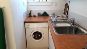 a small kitchen with a washing machine and a sink at Rivendell in Geraldine