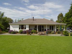 ein weißes Haus mit einem Picknicktisch im Hof in der Unterkunft Rivendell in Geraldine