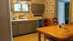 una cucina con un tavolo di legno e un tavolo di legno e un tavolo di legno di Aunt Jane's Guest House a Put-in-Bay