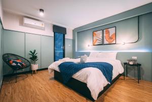 1 dormitorio con 1 cama y 1 silla en Saffron Hill Bangkok en Bangkok