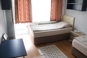 a small room with a bed and a window at Zafer Hostel in Konya