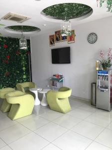a waiting room with green chairs and a tv at GOODY HOTEL in Johor Bahru