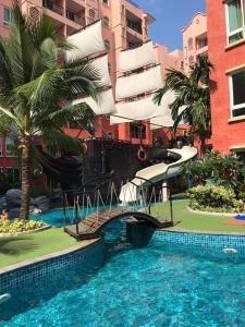 einem großen Pool mit Rutsche vor einem Gebäude in der Unterkunft Seven Seas Condo Resort in Jomtien Beach