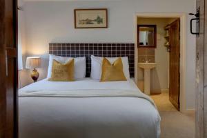 een slaapkamer met een groot wit bed met kussens bij The Moonraker Hotel in Bradford on Avon