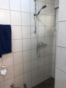 W łazience znajduje się prysznic i niebieski ręcznik. w obiekcie Posthof 33 w mieście Kitzbühel