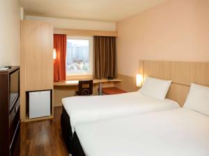a hotel room with two beds and a window at ibis Recife Boa Viagem in Recife