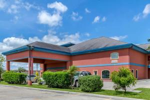 un gran edificio rojo con aparcamiento en Quality Inn & Suites at The Outlets Mercedes-Weslaco, en Mercedes