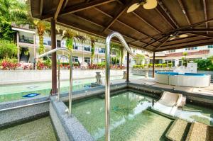 an outdoor pool with a hot tub in a building at Butchard Villas in Yuchi