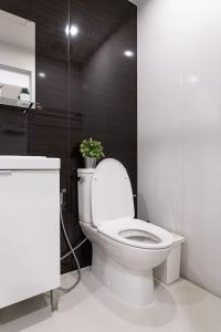 U2 Large 2 Bedrooms 100m to BTS station في بانكوك: حمام مع مرحاض عليه نبات
