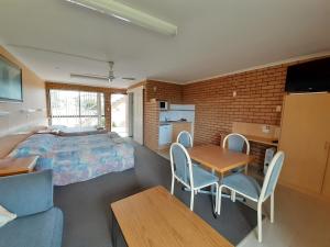 a bedroom with a bed and a table and chairs at Bayview Motor Inn in Eden