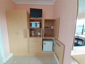 a small room with a tv and a small refrigerator at Bayview Motor Inn in Eden