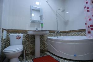 y baño con bañera, aseo y lavamanos. en Anis-Pari Hotel, en Bukhara