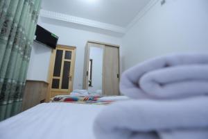 1 dormitorio con cama, ventana y espejo en Anis-Pari Hotel, en Bukhara