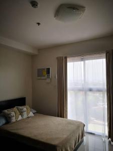 a bedroom with a bed and a large window at Bamboo Bay Condominium near UC Med & Chong Hua Hospital, CDU School, SM Mall, Ayala Mall and IT Park - studio condo unit in Cebu City