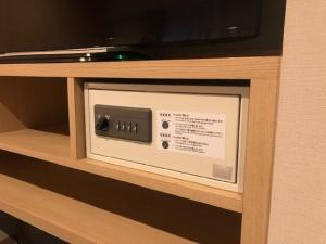 a microwave in a cabinet with a tv in it at Meitetsu Inn Nagoya Kanayama Annex in Nagoya