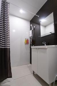 a white bathroom with a shower and a sink at U1 Large 2 bed rooms BTS Udomsuk in Bangkok
