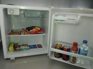 - un réfrigérateur ouvert rempli de nourriture et de boissons dans l'établissement Queens Airport Residence, à Negombo