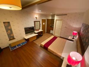 um quarto com uma cama, uma secretária e uma televisão em Dong Zhi Gang Motel em Donggang