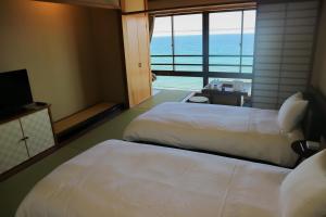 เตียงในห้องที่ HOTEL&RESORT Izu no Ne