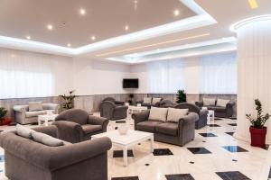 a waiting room with couches and tables and a tv at Klelia Beach Hotel by Zante Plaza in Kalamaki
