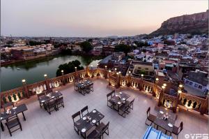a balcony with tables and chairs and a view of a city at Kankariya Heritage in Jodhpur