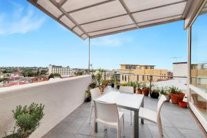 a balcony with a table and chairs on a roof at Coastal Penthouse at Coogee Beach in Sydney