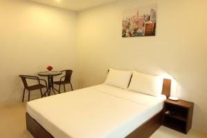 a bedroom with a bed and a small table at 3B Apartment-SHA Extra Plus in Kamala Beach