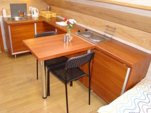 Noclegi "Marek i Karolina" في تشيشين: مطبخ صغير مع طاولة وكراسي خشبية