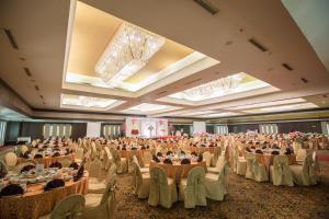 a large banquet hall with tables and chairs at Emerald Garden International Hotel in Medan +37 photos