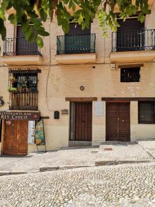 un edificio de ladrillo con dos puertas y ventanas y una calle en Piso para cuatro a los pies de la Alhambra, en Granada