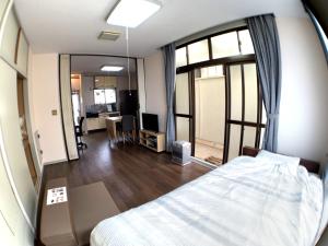 青森市にあるBig Stone Tsukuda 41平米 2Fのベッドと大きな鏡があるホテルの部屋