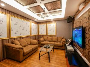 uma sala de estar com 2 sofás e uma televisão de ecrã plano em Sunlight Guest Hotel, Coron, Palawan em Coron