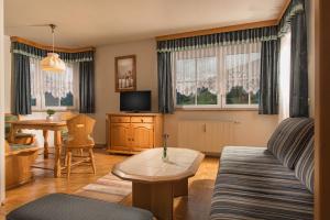 salon z kanapą i stołem w obiekcie Ferienwohnung Salzburg w mieście Bruck an der Großglocknerstraße