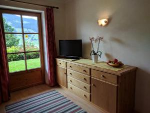 Zimmer mit TV auf einer Kommode mit Fenster in der Unterkunft Landhaus Mayer in Alpbach