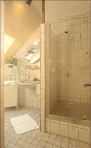 y baño con ducha y lavamanos. en WeinBergHotel Nalbach en Reil