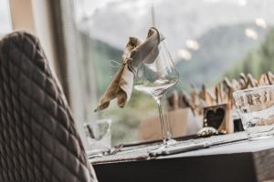 ein Weinglas mit einer Schleife auf dem Tisch in der Unterkunft Hotel Chalet S - Dolomites Design - adults recommended in Wolkenstein in Gröden