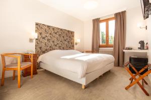 Schlafzimmer mit einem Bett, einem Schreibtisch und einem Stuhl in der Unterkunft Logis Hotel Restaurant du Pont in Ambialet